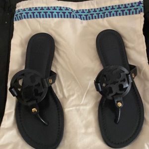 Brand new, never worn Tori Burch black Miller sandals with a canvas shoe bag.